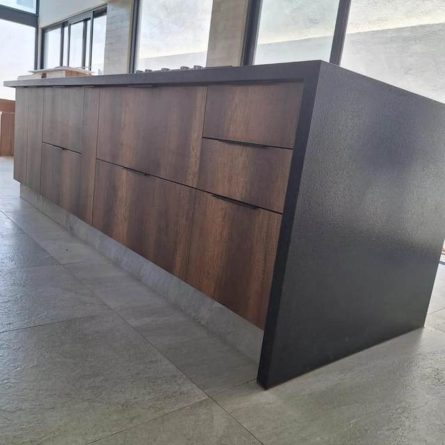 Detalle de isla en madera con canto de granito negro