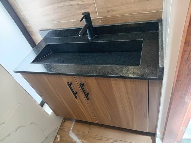 Lavabo individual en mármol negro con gabinete de madera