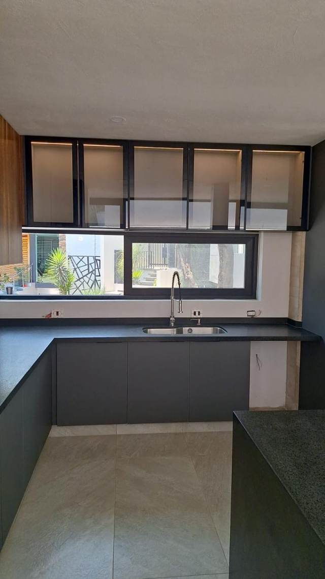 Cubierta de cocina junto a ventana con gabinetes de cristal esmerilado