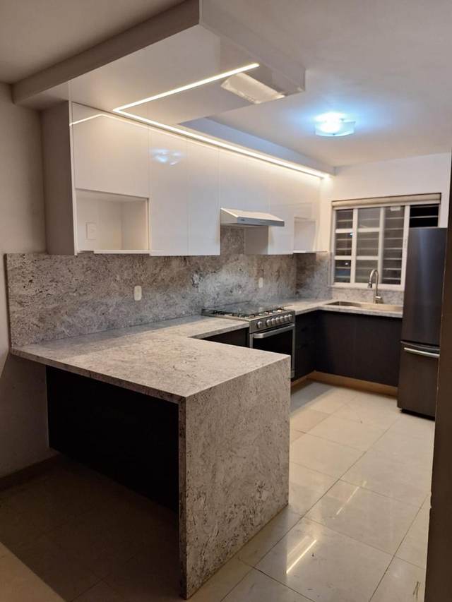 Cubierta de cocina en granito claro veteado con gabinetes negros