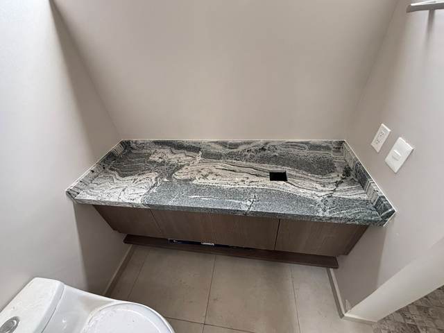 Cubierta de baño en granito gris veteado con desagüe integrado